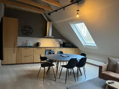 a kitchen and dining room with a table and chairs at Nygårdsgaten apartments in Bergen