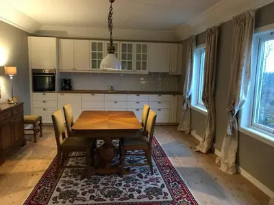 a kitchen with a wooden table with chairs and a dining room at Moldegaard Farmhouse - Apartment B in Moldegard