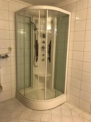 a shower with a glass door in a bathroom at Moldegaard Farmhouse - Apartment B in Moldegard