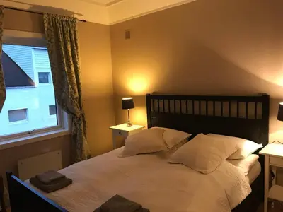 a bedroom with a bed with two pillows and a window at Moldegaard Farmhouse - Apartment B in Moldegard