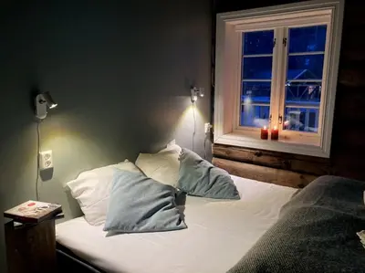 a bedroom with a bed with pillows and a window at Valsøya in Valsøyfjord