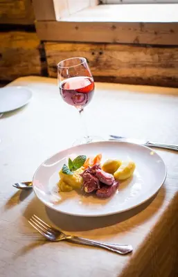 a plate of food and a glass of wine on a table at Valsøya in Valsøyfjord