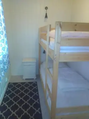 a bunk bed room with two bunk beds and a rug at Bjørgo Gard - Stegastein in Aurland