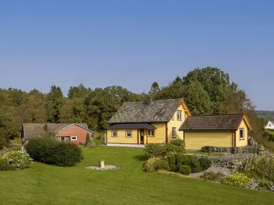 a yellow house in the middle of a yard at Holiday Home Rødehuset by Interhome in Gjelland