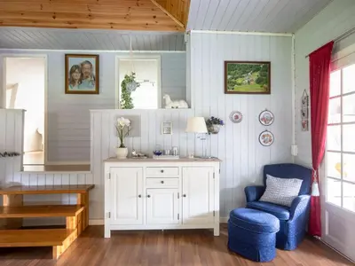 a room with a white cabinet and a blue chair at Holiday Home Rødehuset by Interhome in Gjelland