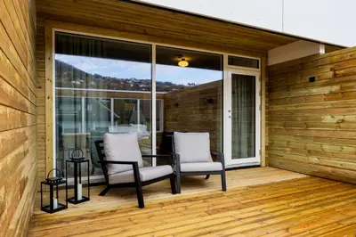 a patio with two chairs and a table on a deck at Stryn House Hotel in Stryn