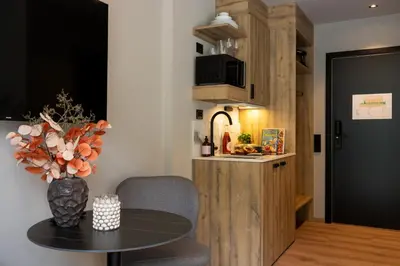 a living room with a table and a kitchen at Stryn House Hotel in Stryn