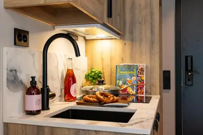 a kitchen counter with a sink and a bottle of wine at Stryn House Hotel in Stryn