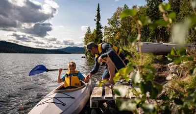 a man and a child in a kayak on a lake at Spåtind Fjellhotell in Nord Torpa