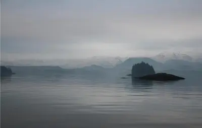 a island in the middle of a body of water with mountains at 1 Bedroom Lovely Apartment In Svortevik in Svortevik