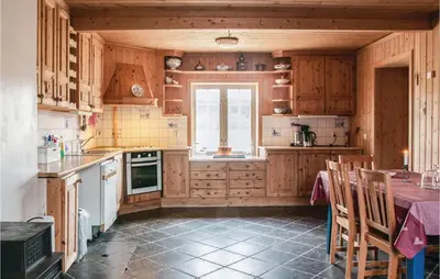 a kitchen with wooden cabinets and a table and a window at Beautiful Home In Tynset With Kitchen in Tynset