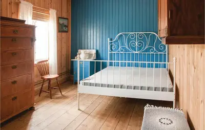 a bedroom with a bed and a blue wall at Beautiful Home In Tynset With Kitchen in Tynset
