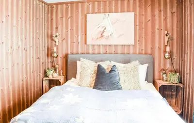 a bedroom with a bed with pillows and a painting at Gorgeous Home In Sjusjøen With Wifi in Sjusjøen
