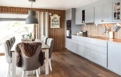 a kitchen with white cabinets and a table with chairs at Gorgeous Home In Sjusjøen With Wifi in Sjusjøen