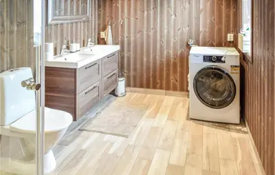 a bathroom with a washing machine and a sink at Gorgeous Home In Sjusjøen With Wifi in Sjusjøen