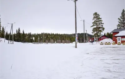 a snow covered parking lot with benches and a building at Nice Home In Gol With Kitchen in Gol