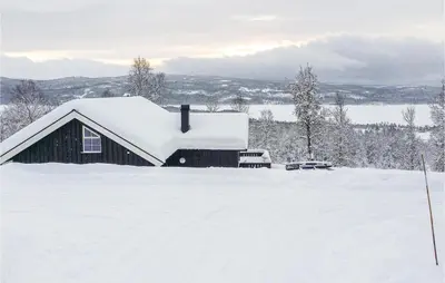 a barn covered in snow next to a snow covered field at Stunning Home In Hemsedal With Kitchen in Hemsedal