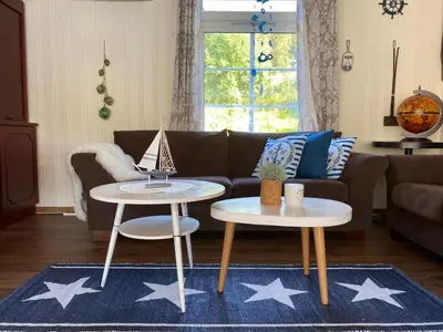 a living room with two tables and a couch at Eidsvåg Fjordhotell in Eidsvåg