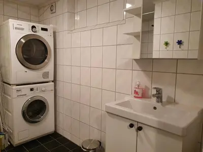a bathroom with a washing machine and a sink at Bårdshaug Studio Apartment in Orkanger