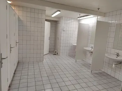 a tiled bathroom with two sinks and two toilets at Halland Camping in Berkåk