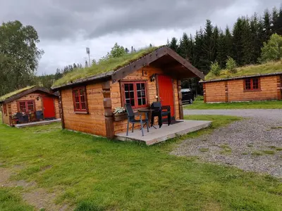 a small log cabin with a grass roof at Halland Camping in Berkåk
