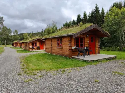 a small log cabin with a grass roof at Halland Camping in Berkåk