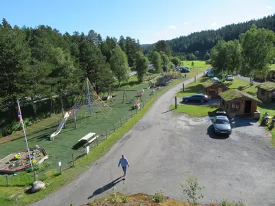 a person walking in a park with a playground at Halland Camping in Berkåk