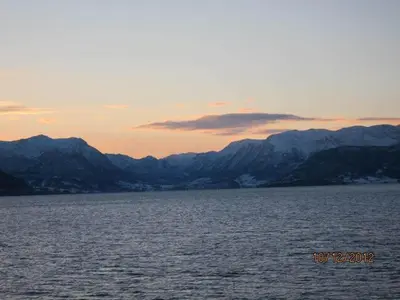 a large body of water with mountains in the background at Presthus Gård in Ølve