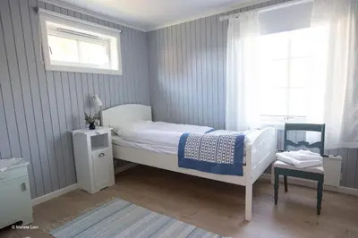a bedroom with a white bed and a window at Kirkvollen pilegrimsgård in Tydal