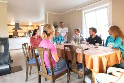 a group of people sitting around a table at Kirkvollen pilegrimsgård in Tydal