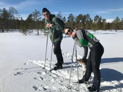 two men standing on skis in the snow at Kirkvollen pilegrimsgård in Tydal