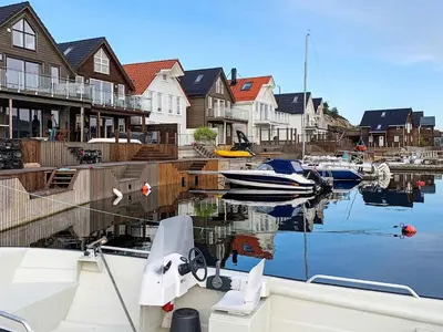 a boat is docked in a marina with houses at 8 person holiday home in Urangsvåg in Ervik