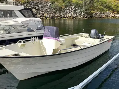 a white boat is docked in the water at 8 person holiday home in Urangsvåg in Ervik
