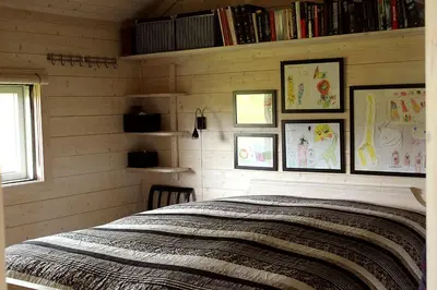 a bedroom with a bed with pictures on the wall at Lev-Vel - 10 person cabin in Ål