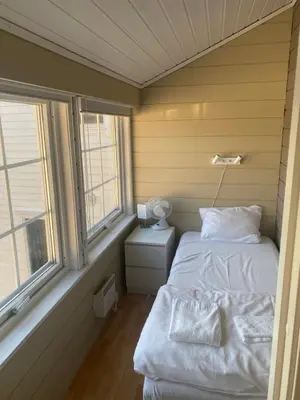 a small room with two beds and two windows at Frimannsbuda in Selje