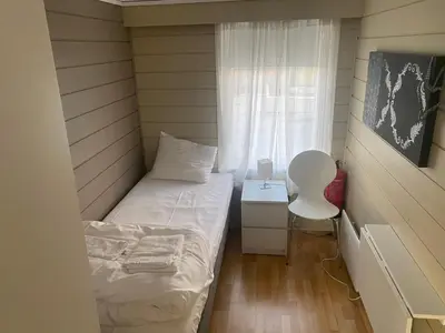 a small room with a bed and a chair at Frimannsbuda in Selje