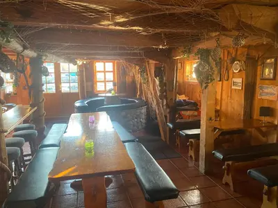 a restaurant with a wooden table and benches in it at Frimannsbuda in Selje