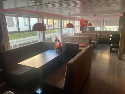 a restaurant with couches and a table and chairs at Frimannsbuda in Selje