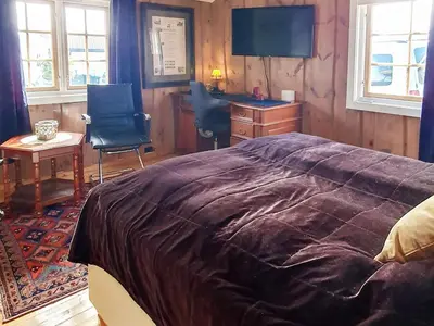 a bedroom with a bed and a desk and chairs at Cozy Cottage Retreat in Trend-By Traum in Frei