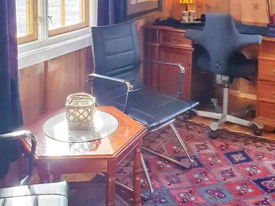a chair and a table in a room at Cozy Cottage Retreat in Trend-By Traum in Frei