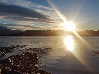 a sun setting over a body of water at Cozy Cottage Retreat in Trend-By Traum in Frei