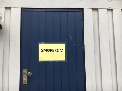 a sign on the door of a blue door with the word snowperson at Torpomoen in Torpo