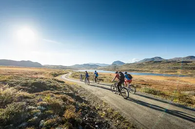 a group of people riding bikes down a dirt road at Torpomoen in Torpo