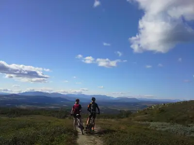 two people riding bikes on a dirt trail on a hill at Torpomoen in Torpo