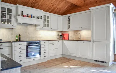 a kitchen with white cabinets and a wooden ceiling at Cozy Home In Hemsedal With Kitchen in Hemsedal