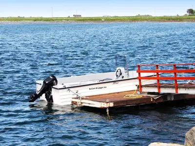 a boat tied up to a dock in the water at 6 person holiday home in Brekstad in Brekstad