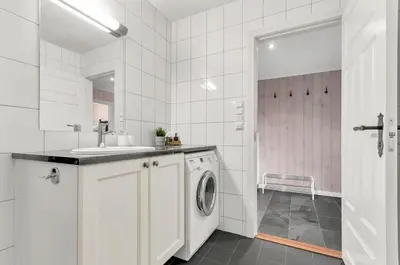 a white laundry room with a sink and a washing machine at Gaustatoppen Apartment in Rjukan