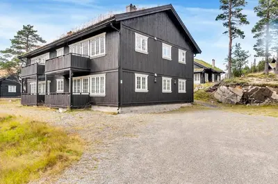 a black house with white windows and a driveway at Gaustatoppen Apartment in Rjukan