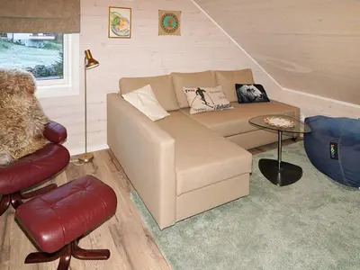 a living room with a couch and a table at 8 person holiday home in Åram in Sandvik