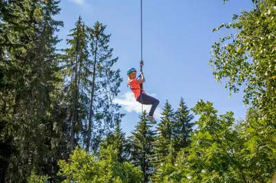 a person is jumping in the air with trees at Topcamp Hallingdal - Ål in Ål